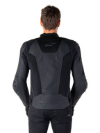Alpinestars Missile V3 Airflow skinnjacka i svart sedd bakifrån på en modell, som visar omfattande perforerade paneler och mesh-inlägg på ryggen för ventilation, med präglad logotyp på den nedre delen av ryggen.