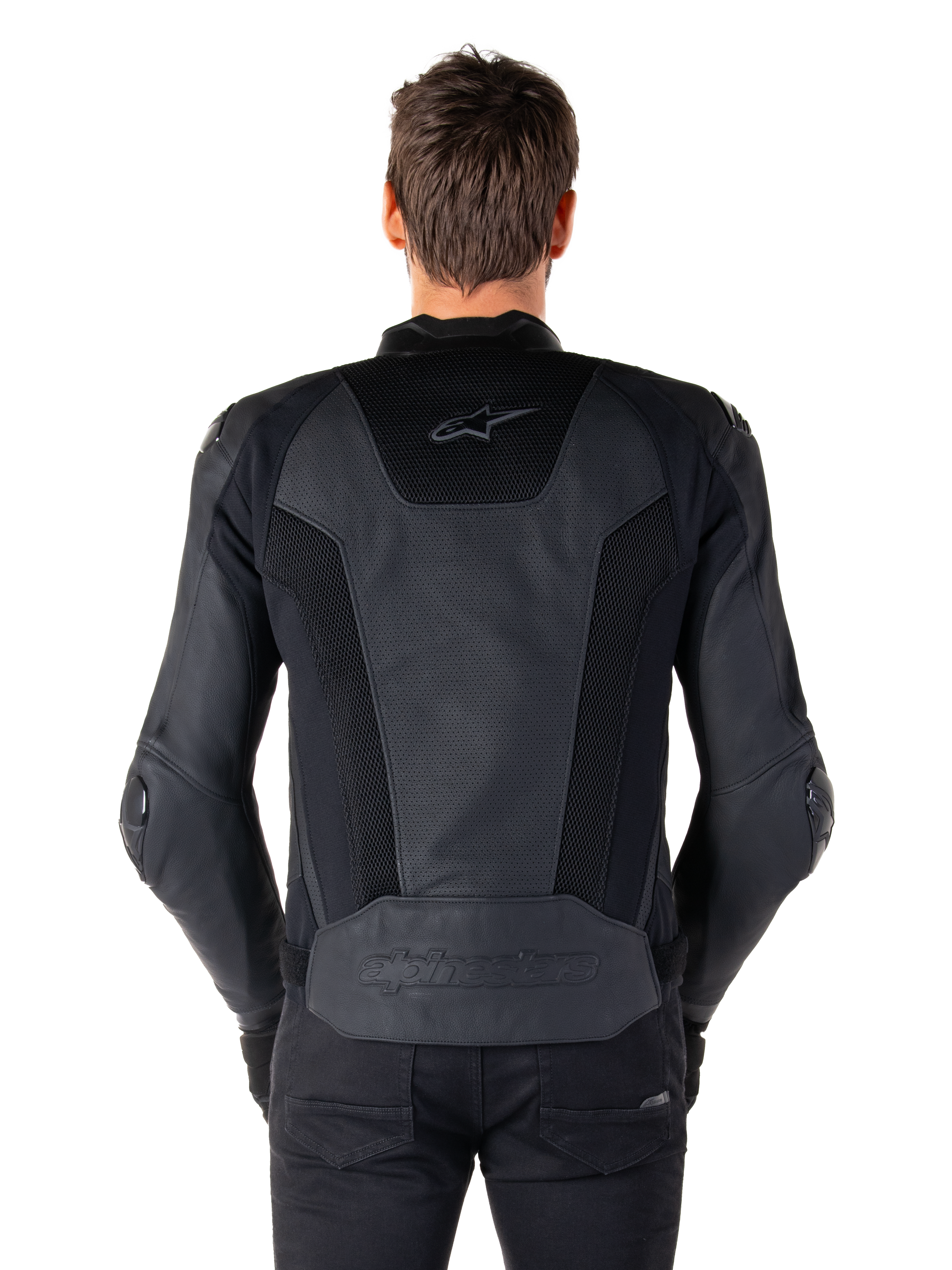 Alpinestars Missile V3 Airflow skinnjacka i svart sedd bakifrån på en modell, som visar omfattande perforerade paneler och mesh-inlägg på ryggen för ventilation, med präglad logotyp på den nedre delen av ryggen.