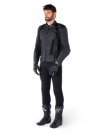 Alpinestars Missile V3 Airflow skinnjacka, svart, buren av en förare med matchande svarta byxor, handskar och stövlar, med perforerat nötläder för maximal ventilation och DFS-axelskydd, premium sportmotorcykelutrustning