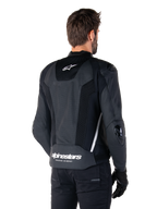 Alpinestars Missile V3 Airflow läderjacka, svart och vit, vy bakifrån med perforerat läder och meshpaneler för maximal ventilation, vit Alpinestars-logotyp på nedre ryggen och stjärnlogotyp i nacken, bärs med svart MC-utrustning, förstklassig racingdesign.