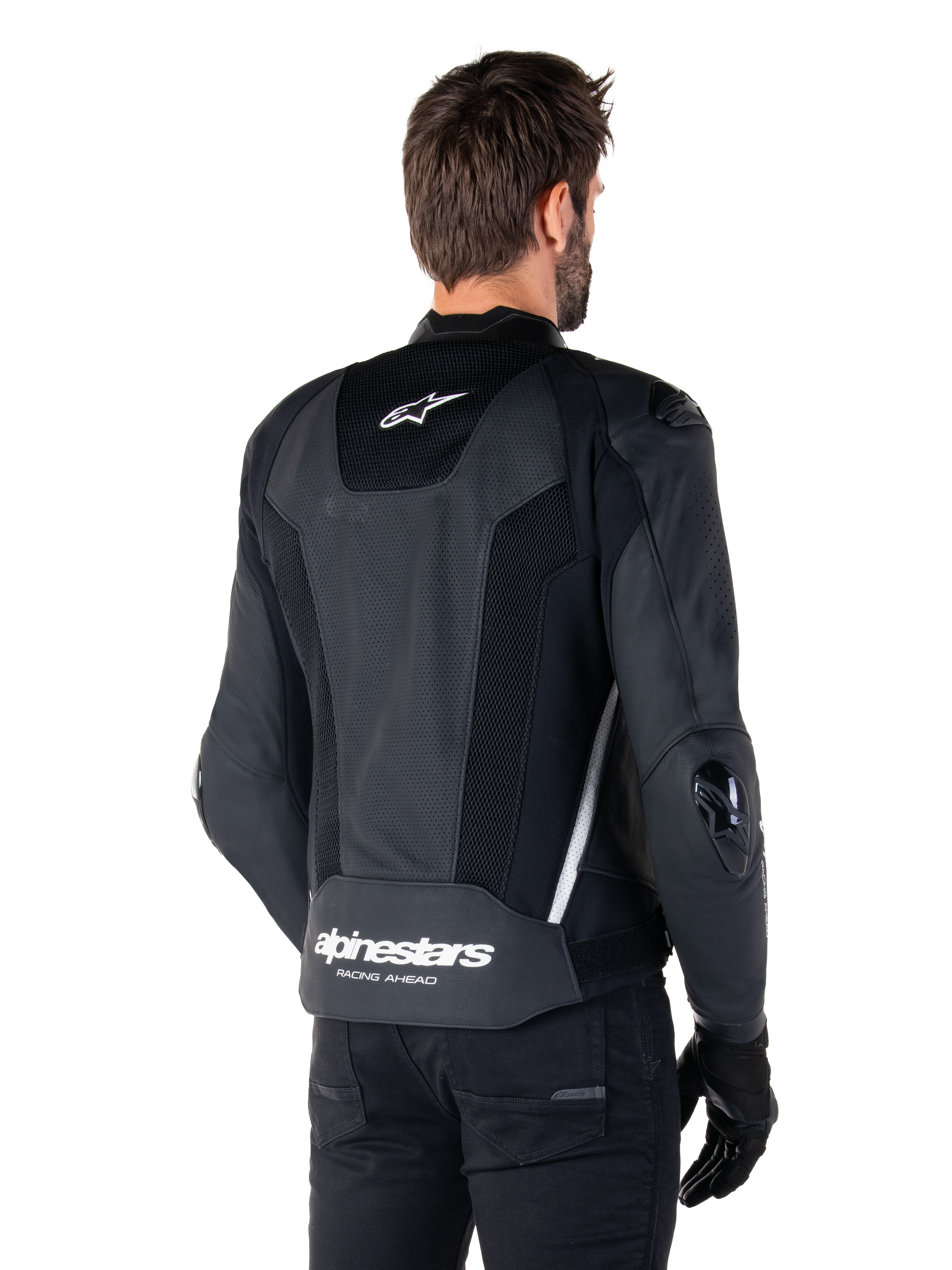 Alpinestars Missile V3 Airflow läderjacka, svart och vit, vy bakifrån med perforerat läder och meshpaneler för maximal ventilation, vit Alpinestars-logotyp på nedre ryggen och stjärnlogotyp i nacken, bärs med svart MC-utrustning, förstklassig racingdesign.