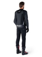 Alpinestars Missile V3 Airflow skinnjacka, svart och vit, vy bakifrån buren med svarta tekniska byxor och racingstövlar, med perforerade läderpaneler på ryggen och tydlig Alpinestars-logotyp på nedre delen av ryggen.