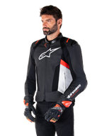 Alpinestars Missile V3 Airflow Leather Jacket, Black White and Red Fluo, Racing Sport Motorcycle Jacket, worn by model with matching gloves, featuring perforated leather panels, large white chest logo, and black shoulder sliders.