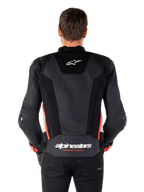 Rear view of a person wearing the Alpinestars Missile V3 Airflow Leather Jacket in Black White Red Fluo, featuring extensive perforated leather panels for ventilation, a small Alpinestars logo on the upper back, and bold 'alpinestars RACING AHEAD' branding on the lower waist.