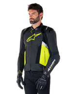 Manlig modell i Alpinestars Missile V3 Airflow läderjacka, svart med neongula och vita detaljer, perforerat läder för maximal ventilation, framträdande gul logotyp på bröstet, svarta handskar och byxor, motorcykelutrustning i racing- och sportstil