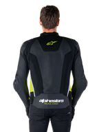 Alpinestars Missile V3 Airflow läderjacka, vy bakifrån, svart med detaljer i gul fluo och vitt, omfattande perforerade läderpaneler för kylning, Alpinestars-logotyper på övre och nedre delen av ryggen, racinginspirerad sportjacka för motorcykel