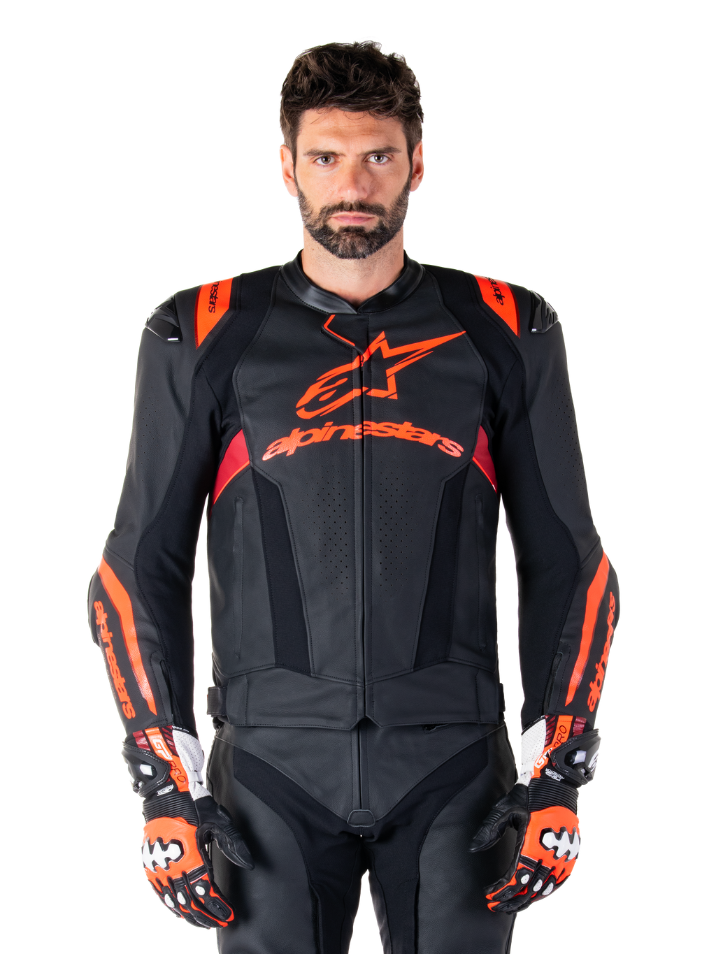 Alpinestars Missile V3 Ignition läderjacka, motorcykelracingjacka, svart och röd fluo, bärs med matchande racinghandskar och läderbyxor, med perforerad ventilation och framträdande Alpinestars-logotyper, professionell racingutrustning