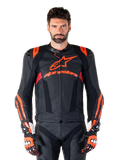 Alpinestars Missile V3 Ignition läderjacka, motorcykelracingjacka, svart och röd fluo, bärs med matchande racinghandskar och läderbyxor, med perforerad ventilation och framträdande Alpinestars-logotyper, professionell racingutrustning