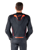 Alpinestars Missile V3 Ignition läderjacka, ryggvy, svart med detaljer i röd fluo och mörkrött, sportig aero-hump, Alpinestars-logotyp på ryggen, bärs med matchande svarta läderbyxor, högpresterande racingutrustning för motorcykel