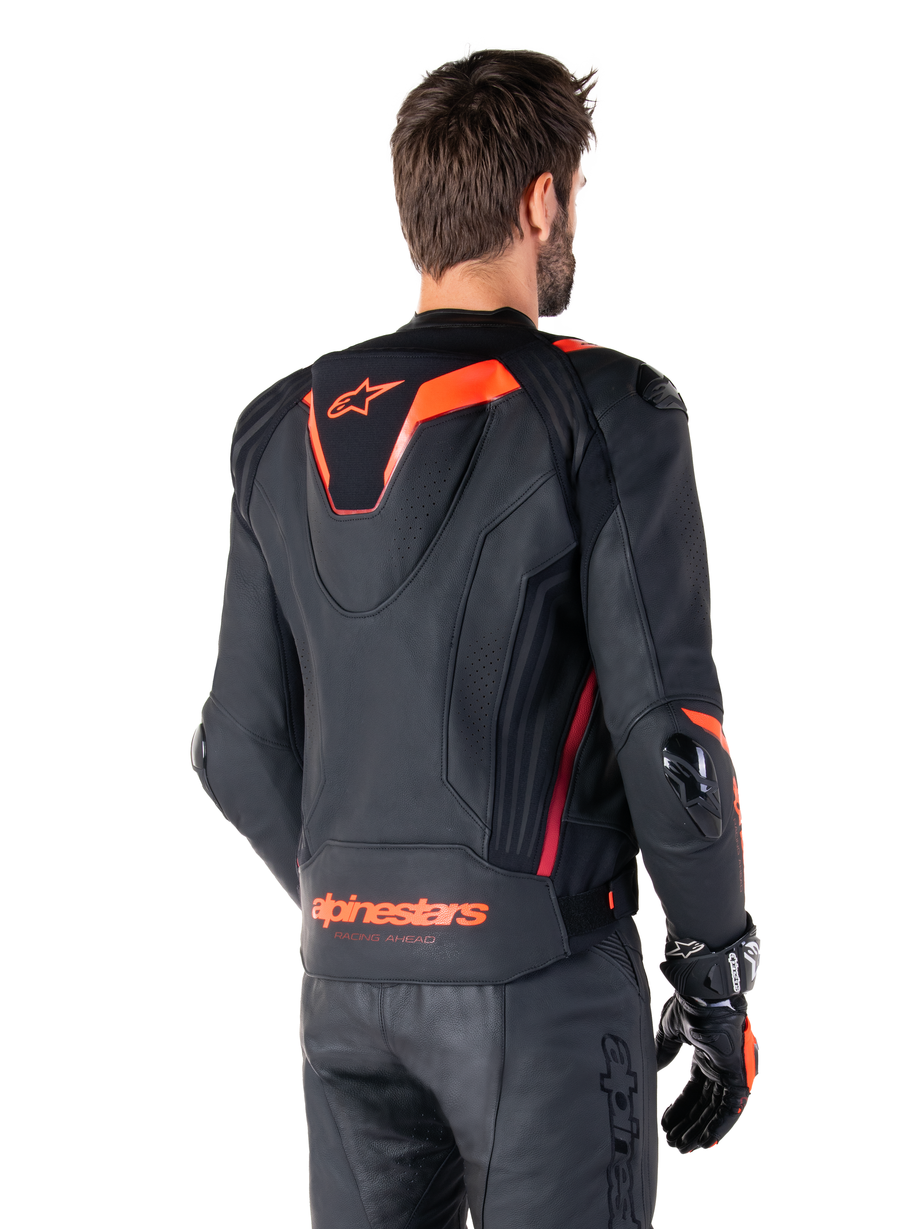 Alpinestars Missile V3 Ignition läderjacka, racingsportjacka för herrar, svart med Red Fluo-detaljer, vy bakifrån som visar den smala aerodynamiska puckeln och Alpinestars-logotyp på nedre delen av ryggen, bärs med svarta läderbyxor och racinghandskar, stilren professionell motorsportdesign