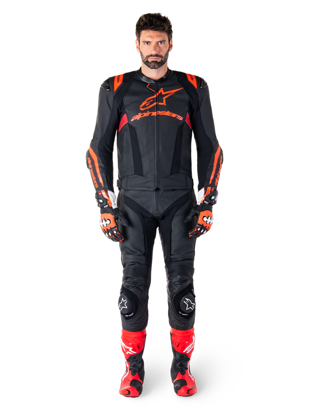 Manlig modell iklädd Alpinestars Missile V3 Ignition läderjacka i svart, röd fluo och mörkröd, komplett racingutrustning för motorcykel inklusive matchande läderbyxor, racinghandskar och stövlar, med framträdande Alpinestars-logotyp på bröstet, framåtvänd pose, professionell sportig MC-utrustning.