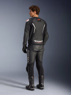 Alpinestars GP Force V2 Air läderjacka, svart och vit, vy bakifrån på modell med en perforerad ryggpanel för ventilation, vit logotyp och röd stjärnlogotyp, buren med matchande racingbyxor i läder, handskar och stövlar