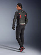 Male model from the back wearing the Alpinestars GP Force V2 Air Leather Jacket in Black Red Fluo, featuring extensive back perforations and bold white branding, paired with black riding jeans, gloves, and black and red riding boots in a studio setting.