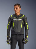 Alpinestars GP Force V2 Air Leather Jacket, Black and Yellow Fluo, perforated leather motorcycle jacket with protective armor and neon accents, worn with matching racing gloves and black pants, athletic sport fit with bold branding