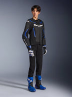 Manlig förare som bär GP Force V2 Airflow läderjacka i Black Metallic Blue, kombinerat med matchande racinghandskar och blå stövlar, med perforerat läder och tydlig Alpinestars-logotyp, professionell motorcykelutrustning för vägkörning.