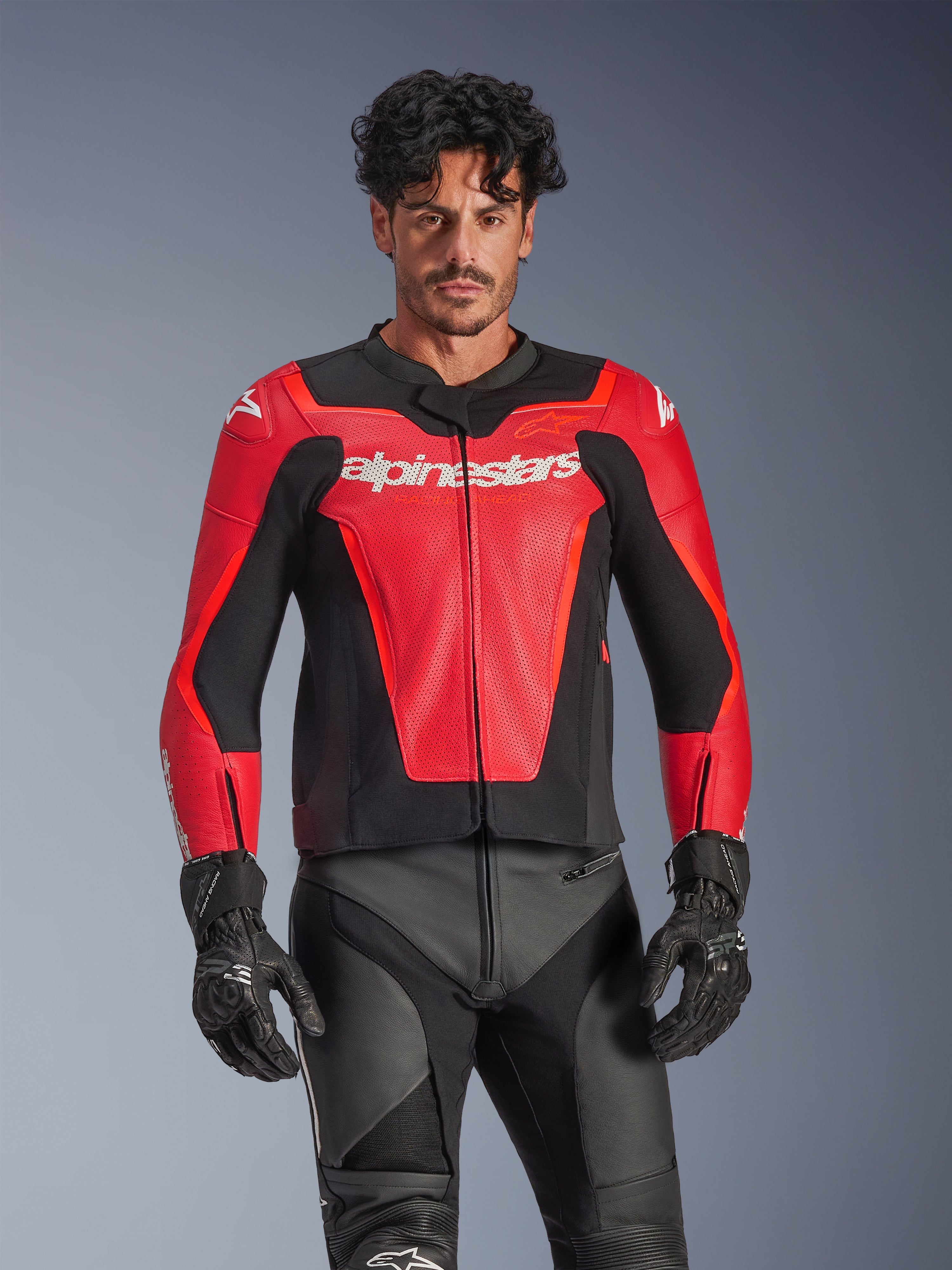 Alpinestars GP Force V2 Air läderjacka, röd och svart motorcykeljacka för racing, perforerad läderkonstruktion med vit Alpinestars-logotyp, bärs av manlig modell och matchas med svarta racingbyxor och handskar