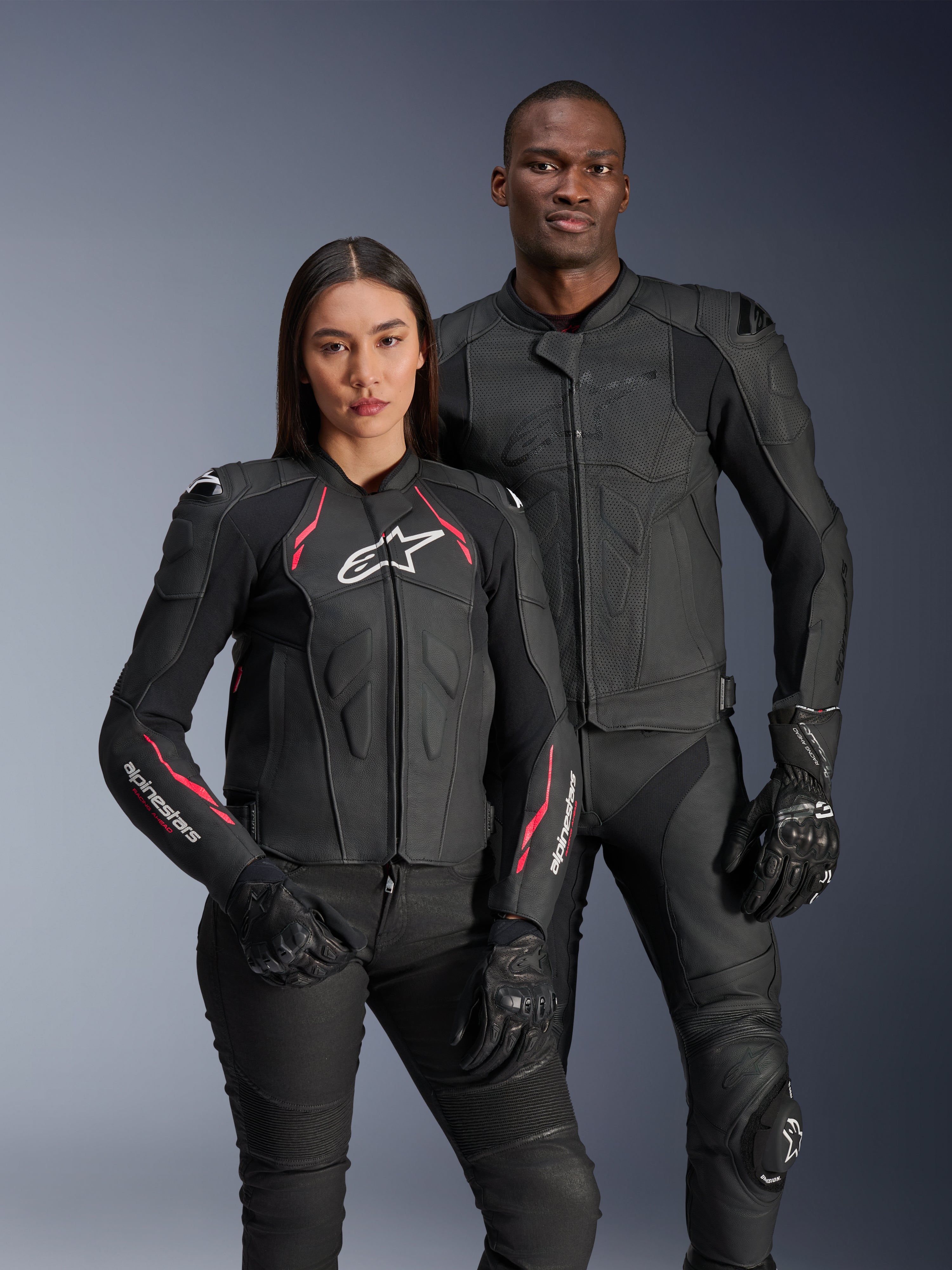Alpinestars Dusk Airflow och Stella Dusk skinnjackor, manlig och kvinnlig förare i svarta mc-jackor av läder, herrejacka med perforerat läder för ventilation, damjacka med röda detaljer och vita logotyper, matchat med svarta körbyxor och handskar, sportig mc-utrustning för hög prestanda