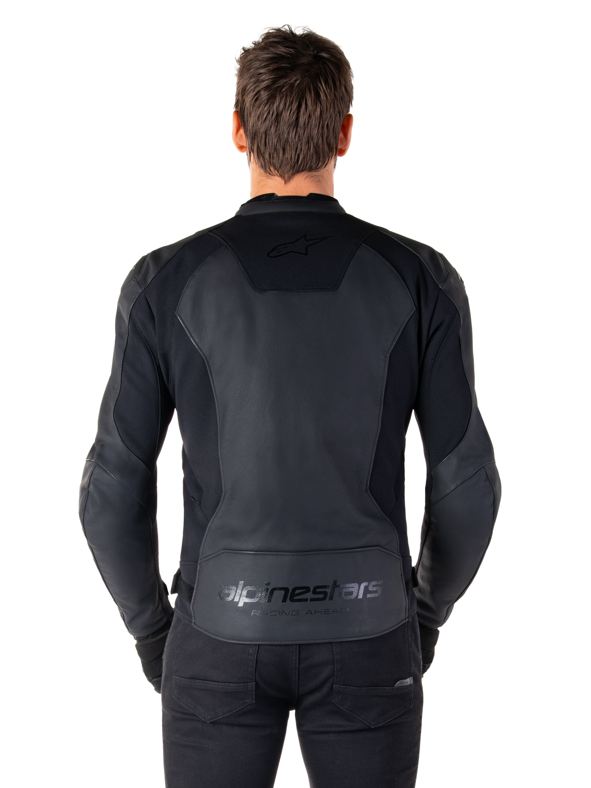 Ryggvy av en man som bär Alpinestars Faster V3 skinnjacka i Black Black, med paneler i premiumläder och flexibla stretchinsatser, subtil 'alpinestars'- och 'RACING AHEAD'-branding på nedre delen av ryggen, atletisk sportpassform för motorcykelkörning.