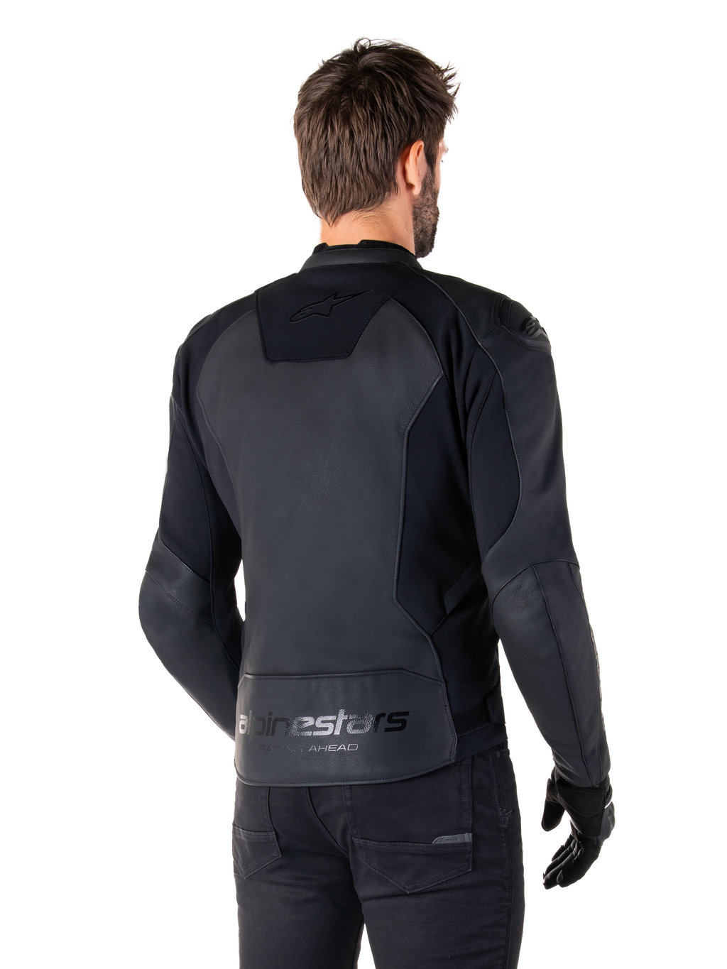 Alpinestars Faster V3 Skinnjacka, Svart, ryggvy av modell som bär den sportiga motorcykeljackan, med 'alpinestars' och 'RACING AHEAD' logotyper på nedre ryggen, premiumläder med matta paneler, modern sportig silhuett för motorcykelkörning