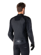Alpinestars Faster V3 Skinnjacka, Svart, ryggvy av modell som bär den sportiga motorcykeljackan, med 'alpinestars' och 'RACING AHEAD' logotyper på nedre ryggen, premiumläder med matta paneler, modern sportig silhuett för motorcykelkörning