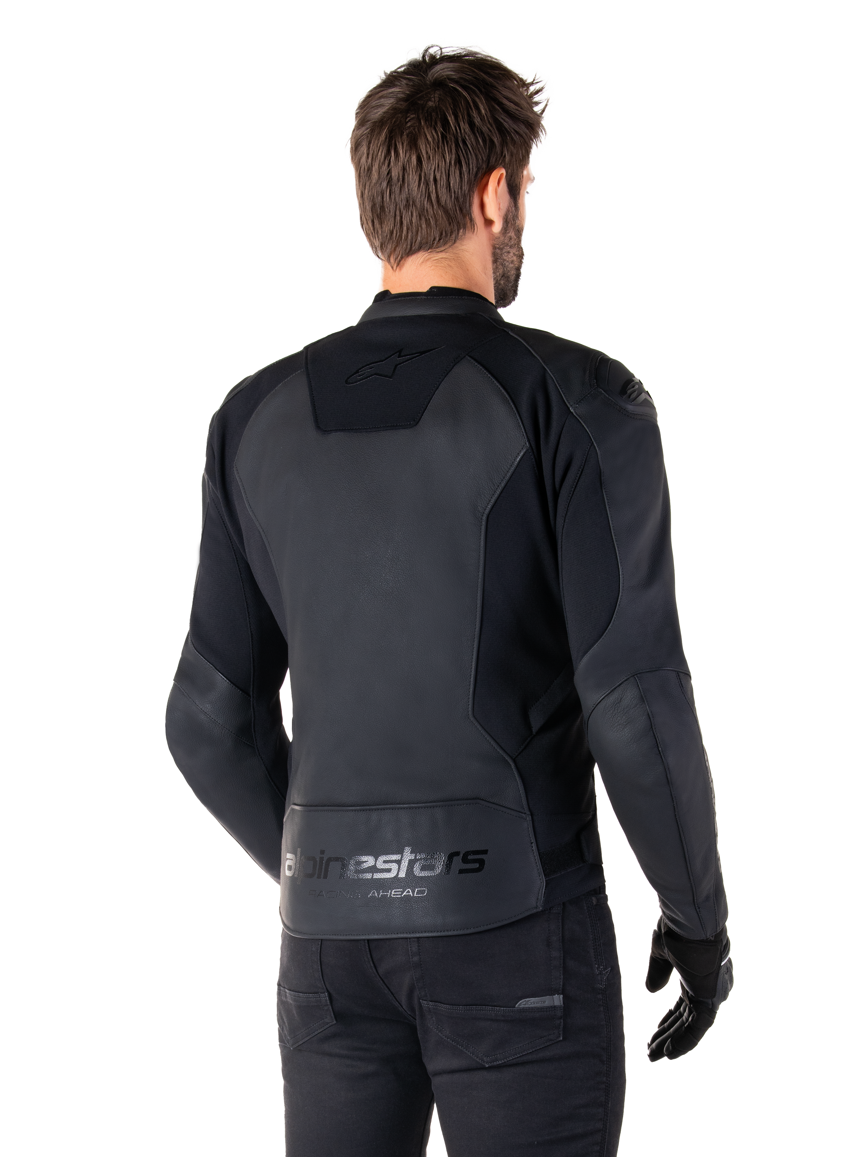 Alpinestars Faster V3 Skinnjacka, Svart, ryggvy av modell som bär den sportiga motorcykeljackan, med 'alpinestars' och 'RACING AHEAD' logotyper på nedre ryggen, premiumläder med matta paneler, modern sportig silhuett för motorcykelkörning