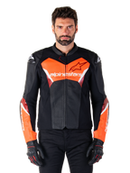 Alpinestars Faster V3 Airflow läderjacka, motorcykeljacka för racing, svart och röd fluo, perforerad läderkonstruktion med vita och röda detaljer, bärs med svarta handskar, högpresterande utrustning för gatkörning