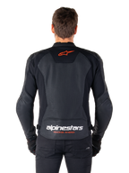 Alpinestars Faster V3 Airflow-läderjacka, svart, vy bakifrån med perforerade läderpaneler för ventilation, röd Alpinestars-stjärnlogotyp och vit logotyp på nedre ryggen, bärs med svarta byxor och handskar.