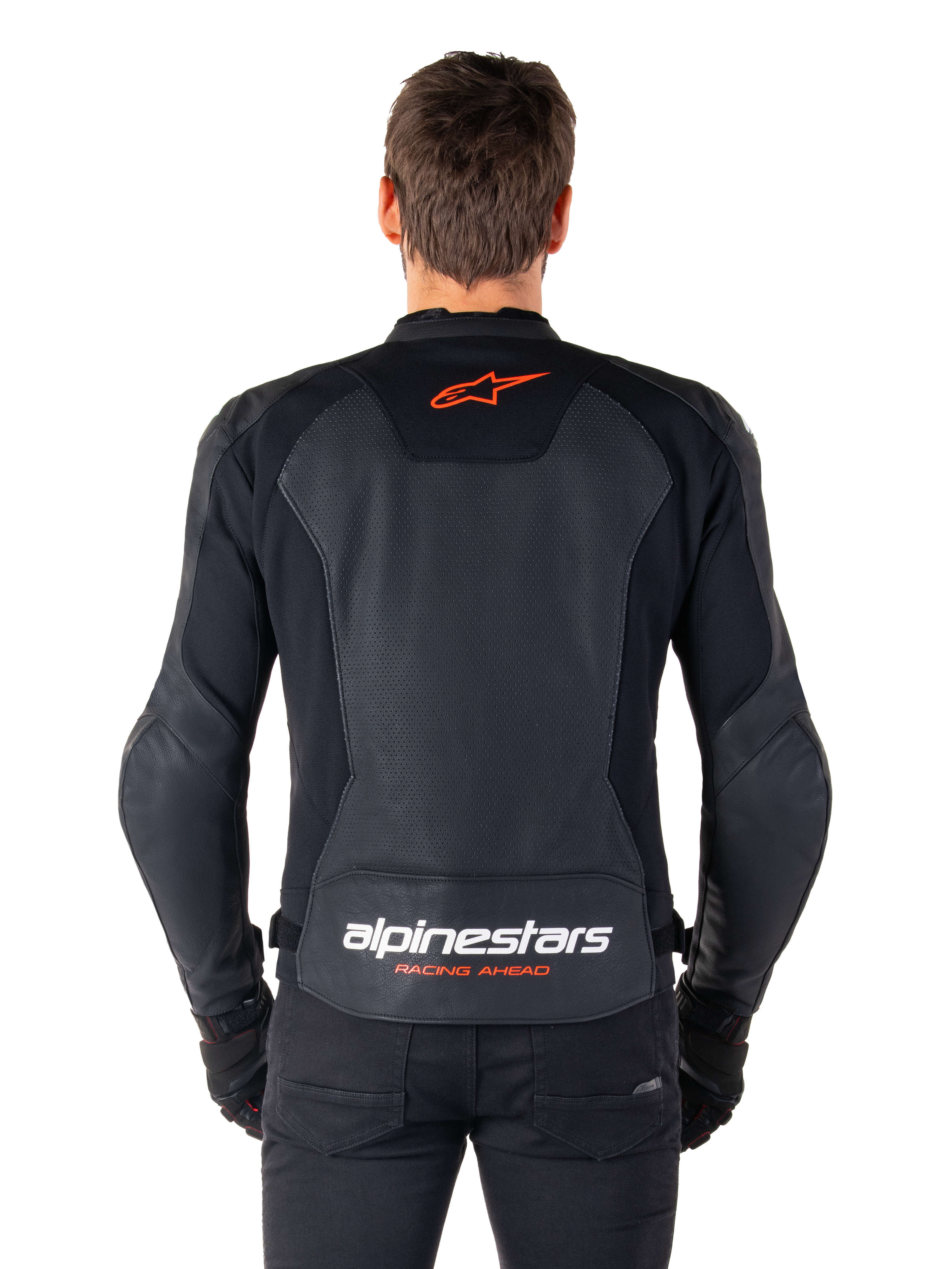 Alpinestars Faster V3 Airflow-läderjacka, svart, vy bakifrån med perforerade läderpaneler för ventilation, röd Alpinestars-stjärnlogotyp och vit logotyp på nedre ryggen, bärs med svarta byxor och handskar.