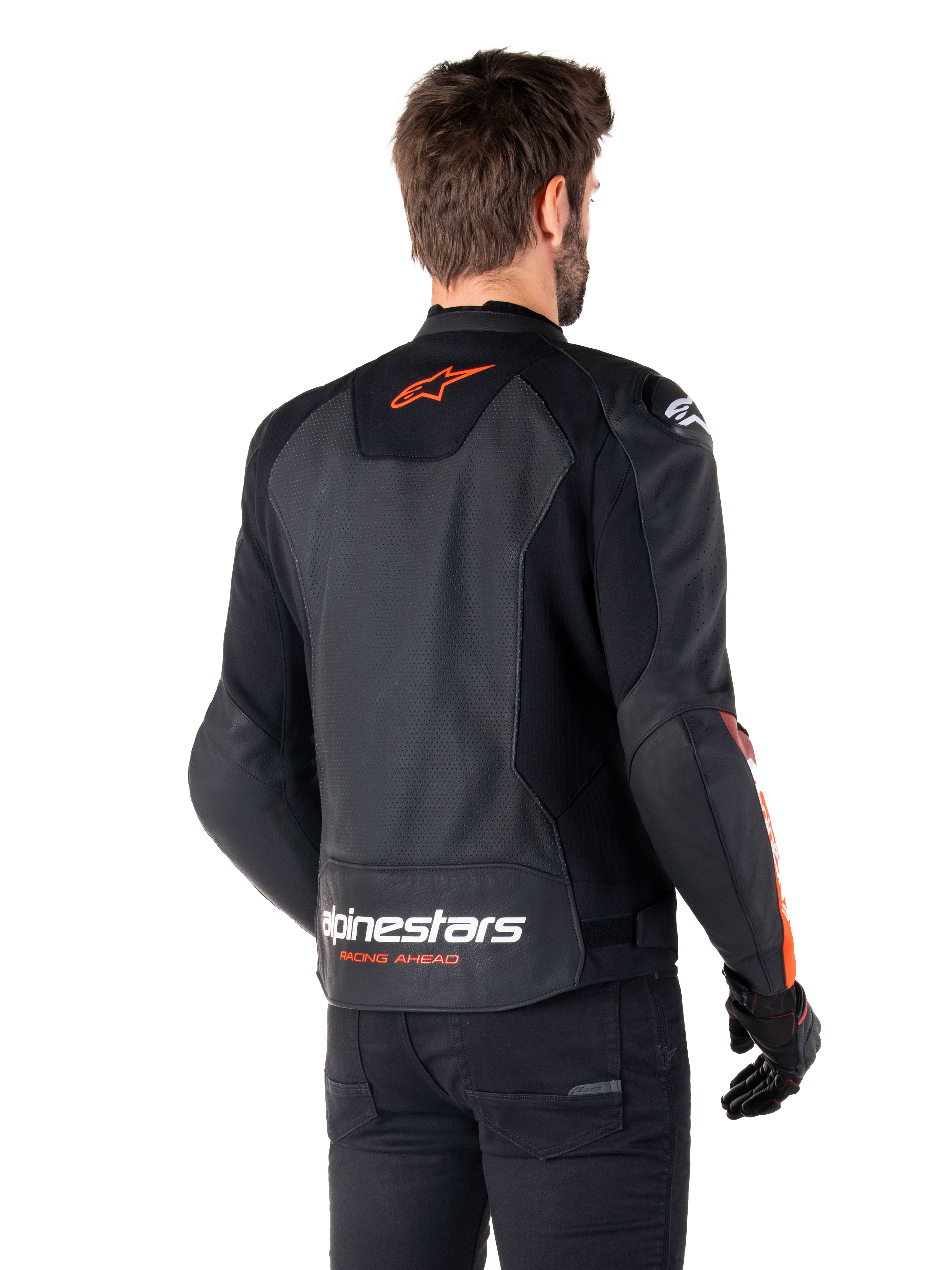 Alpinestars Faster V3 Airflow läderjacka, sportig motorcykeljacka, svart med röd fluo, vy bakifrån, med perforerade läderpaneler, orangeröd Alpinestars-logotyp på övre ryggen och vit logotyp på nedre ryggen, bärs med svarta byxor och handskar, strömlinjeformad racinginspirerad stil