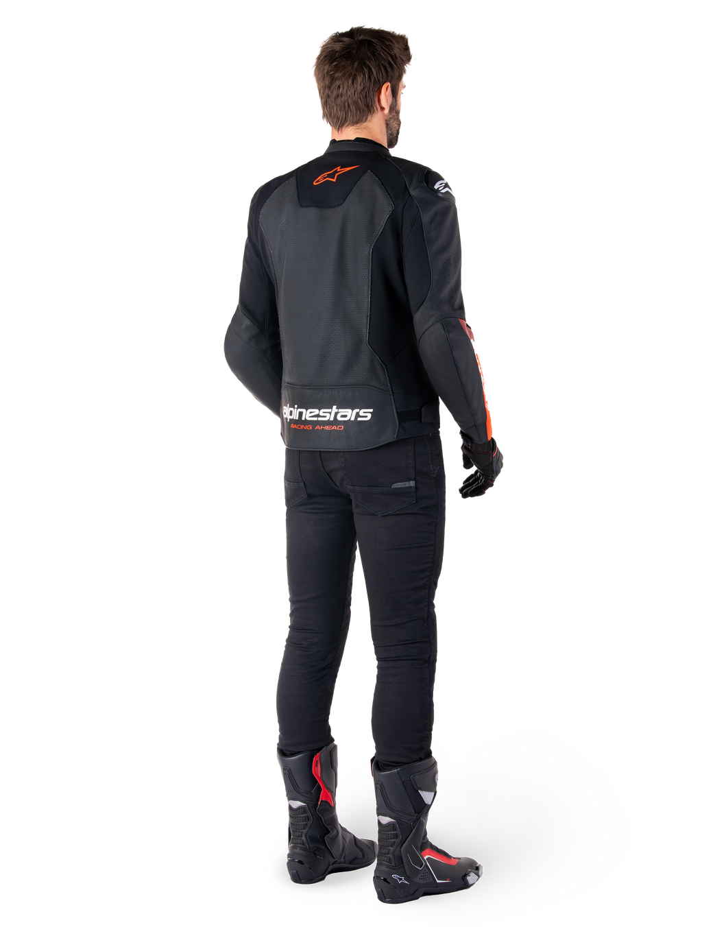 Alpinestars Faster V3 Airflow läderjacka, svart och röd fluo, sedd bakifrån på en förare, med perforerade läderpaneler och framträdande logotyper, bärs med svarta byxor och motorcykelstövlar, sportig mc-utrustning