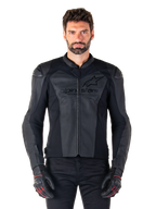 Man iklädd Alpinestars Faster V3 Airflow Leather Jacket, svart motorcykeljacka i läder med perforerade läderpaneler, Alpinestars-logotyp på bröstet, matchad med svarta körhandskar, studiobild framifrån.