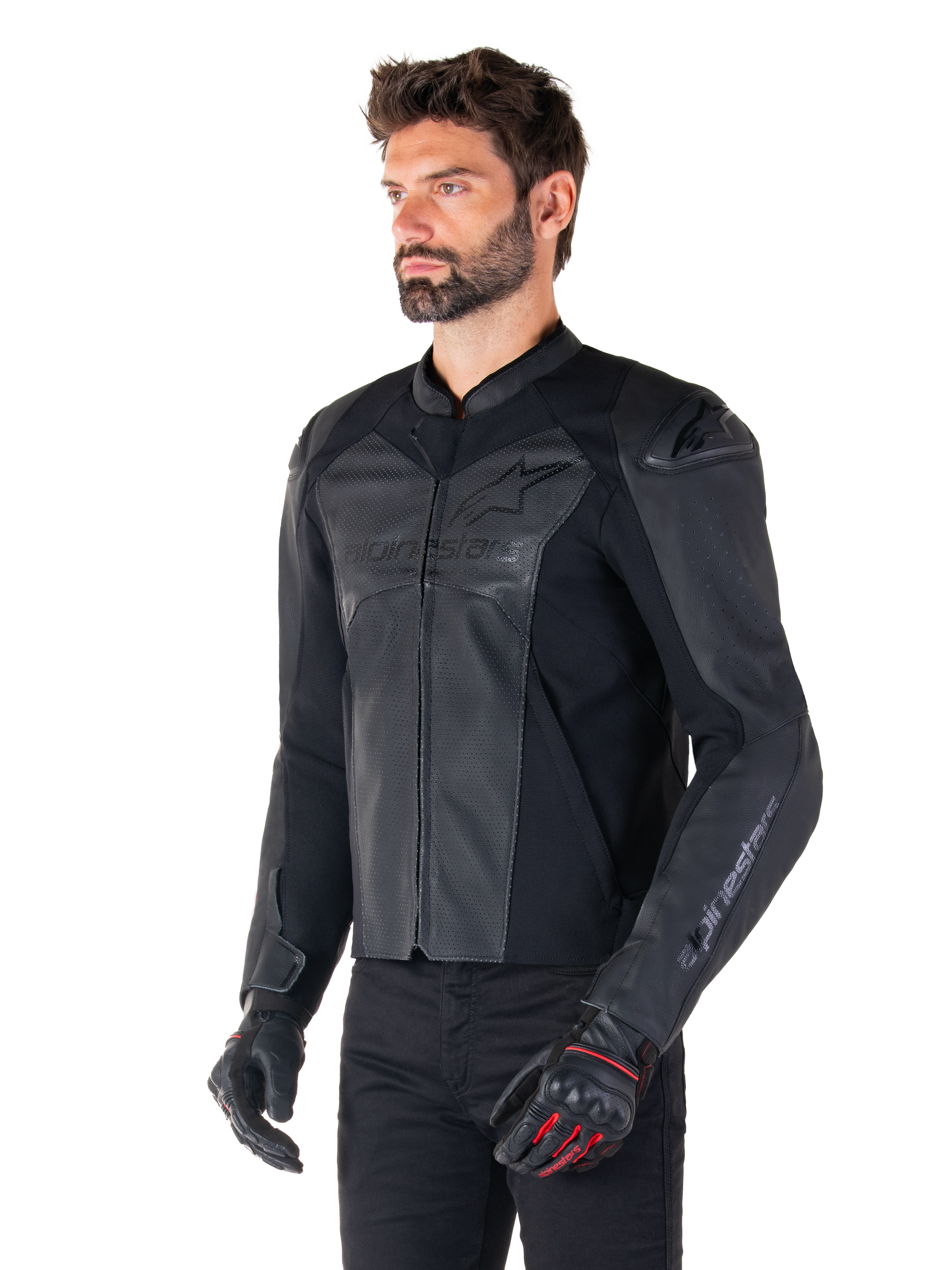 Modell som bär Alpinestars Faster V3 Airflow Läderjacka i Black Black, sportig MC-jacka i läder med perforerat läder och stretchpaneler, matchad med svarta byxor och svarta handskar med röda detaljer, stilren racing-inspirerad design
