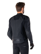 Alpinestars Faster V3 Airflow läderjacka, svart, ryggvy av en man som bär en sportig MC-jacka i läder med perforerade ryggpaneler, stretchinsatser och Alpinestars-märkning på den nedre fållen, kombinerad med svarta byxor och handskar