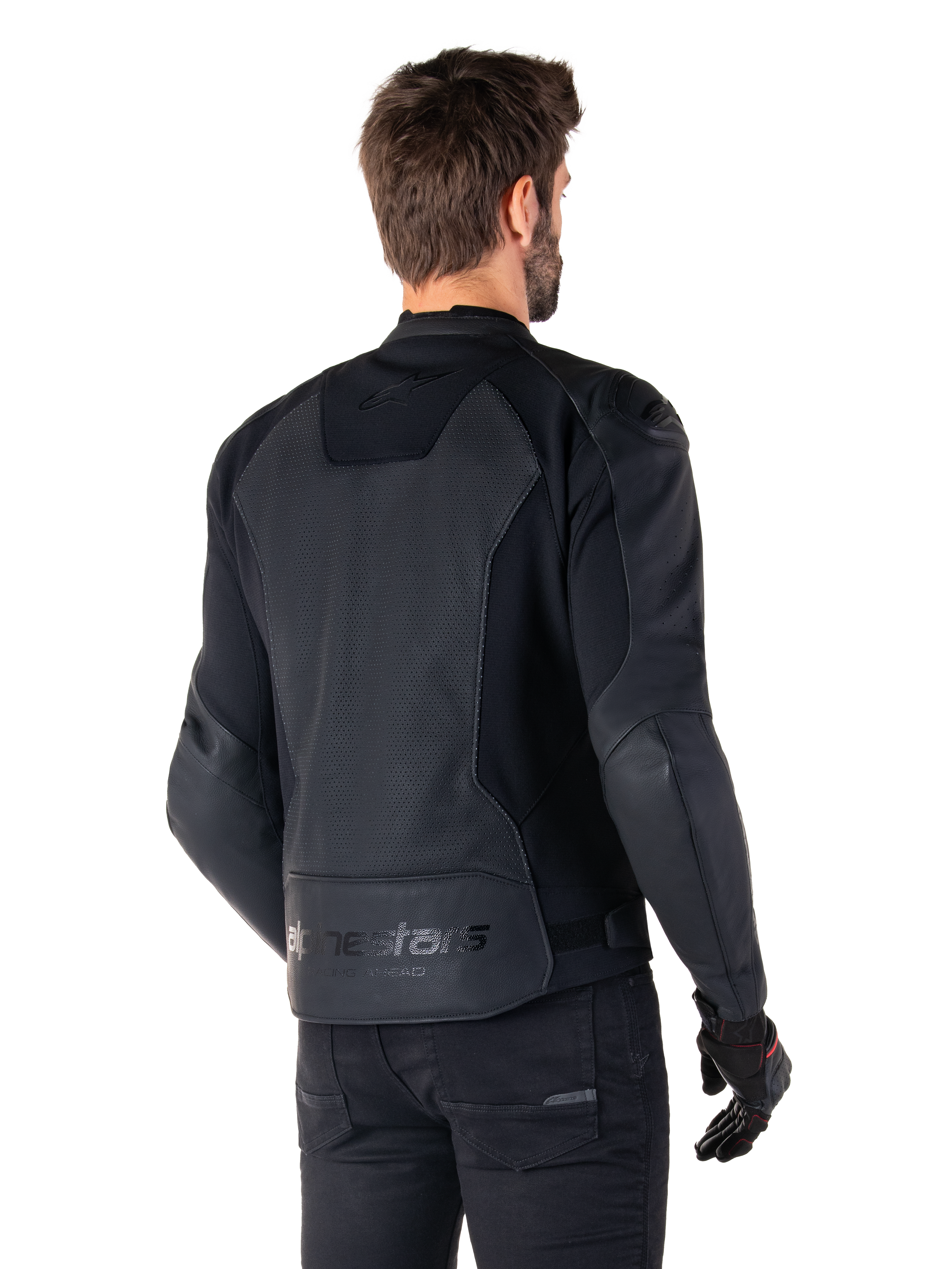 Alpinestars Faster V3 Airflow läderjacka, svart, ryggvy av en man som bär en sportig MC-jacka i läder med perforerade ryggpaneler, stretchinsatser och Alpinestars-märkning på den nedre fållen, kombinerad med svarta byxor och handskar