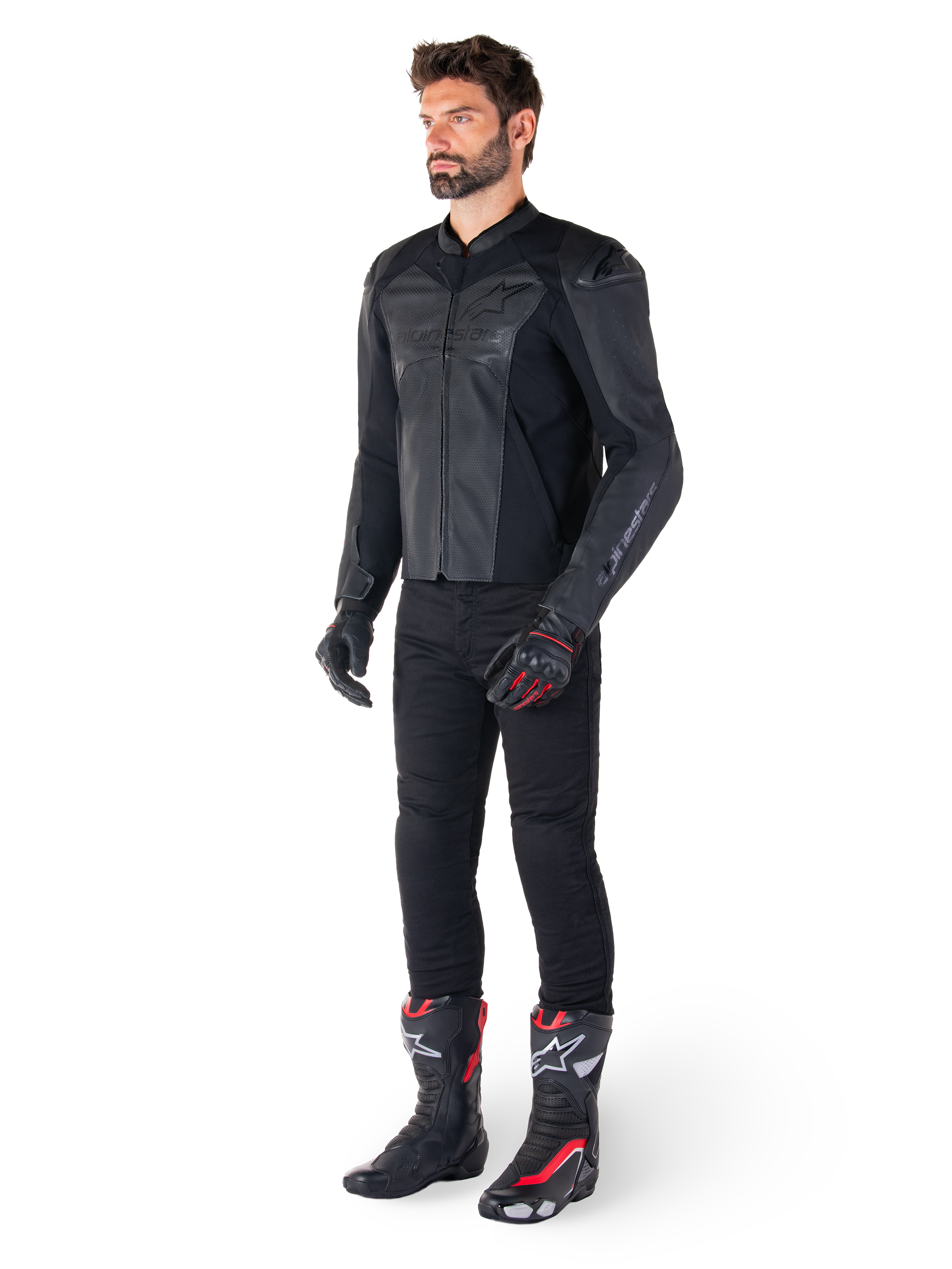 Man i Alpinestars Faster V3 Airflow läderjacka i Black Black, svarta byxor, svarta och röda motorcykelhandskar, svarta racingstövlar med röda och vita detaljer, komplett sportutrustning för motorcykelkörning