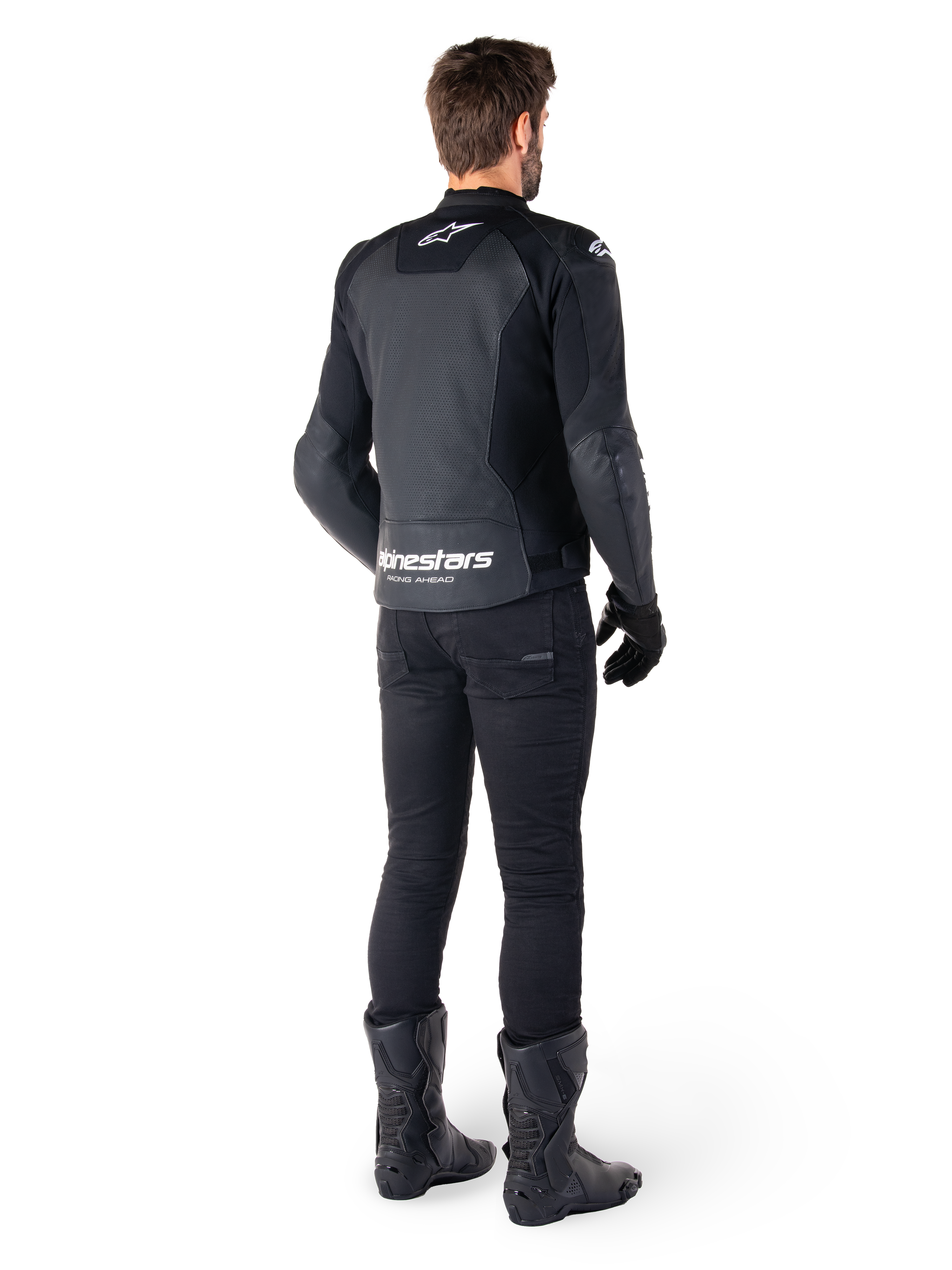 Alpinestars Faster V3 Airflow Leather Jacket, Black and White, rear view showing perforated leather panels and prominent Alpinestars branding on the lower back, worn by a rider with black riding pants, gloves, and boots.