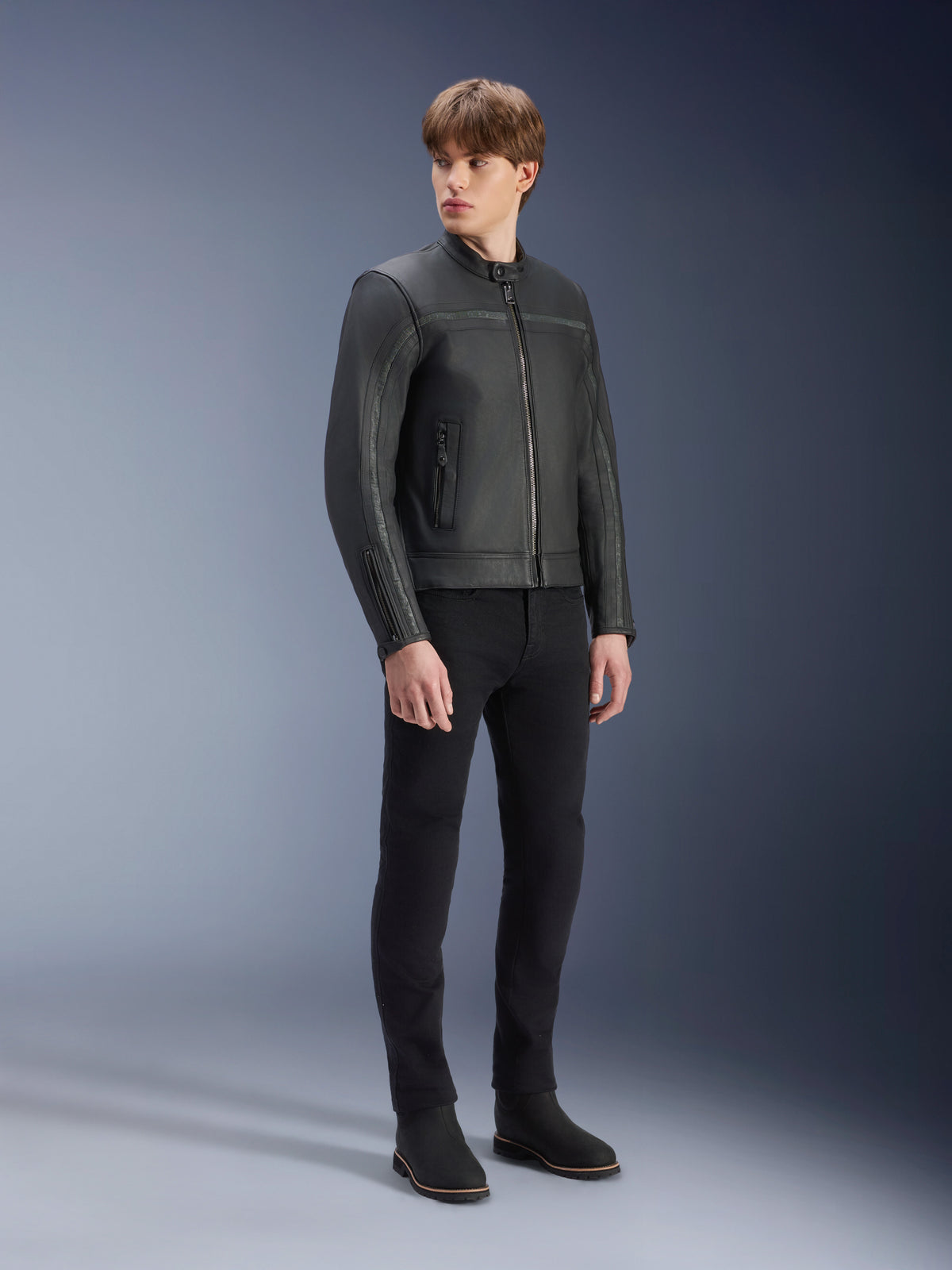 Alpinestars Dyno skinnjacka i svart, motorcykeljacka i premiumläder, bärs av en manlig modell med svarta slim-fit-byxor och svarta stövlar, arvinspirerad minimalistisk design för urban modern körning, studiomiljö.