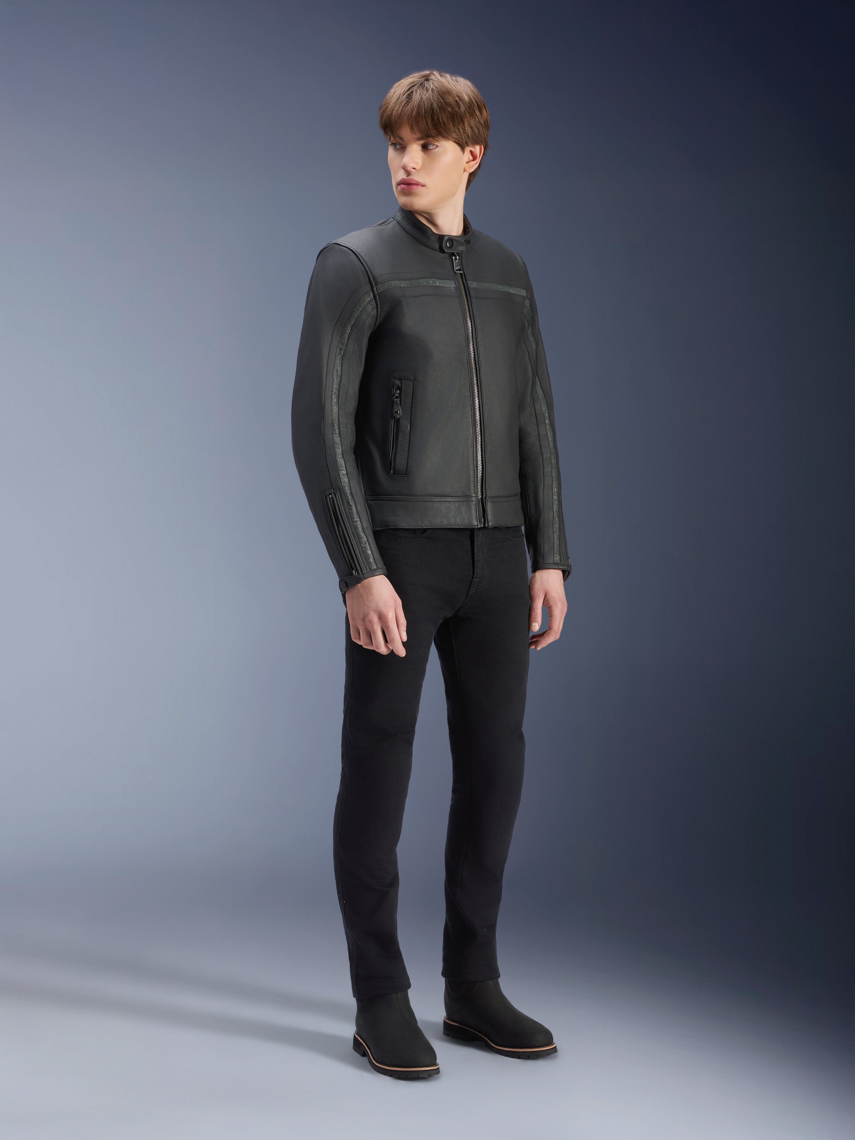 Alpinestars Dyno skinnjacka i svart, motorcykeljacka i premiumläder, bärs av en manlig modell med svarta slim-fit-byxor och svarta stövlar, arvinspirerad minimalistisk design för urban modern körning, studiomiljö.