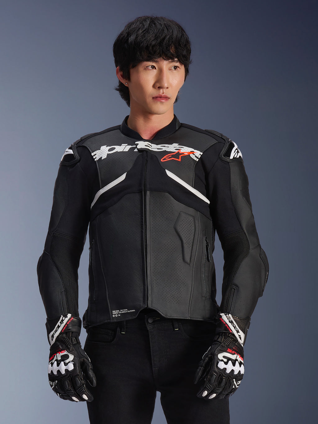 Alpinestars Atem V5 läderjacka, motorcykelracingjacka, svart med vita och röda detaljer, premium läderkonstruktion med inbyggda skydd, bärs med matchande racinghandskar