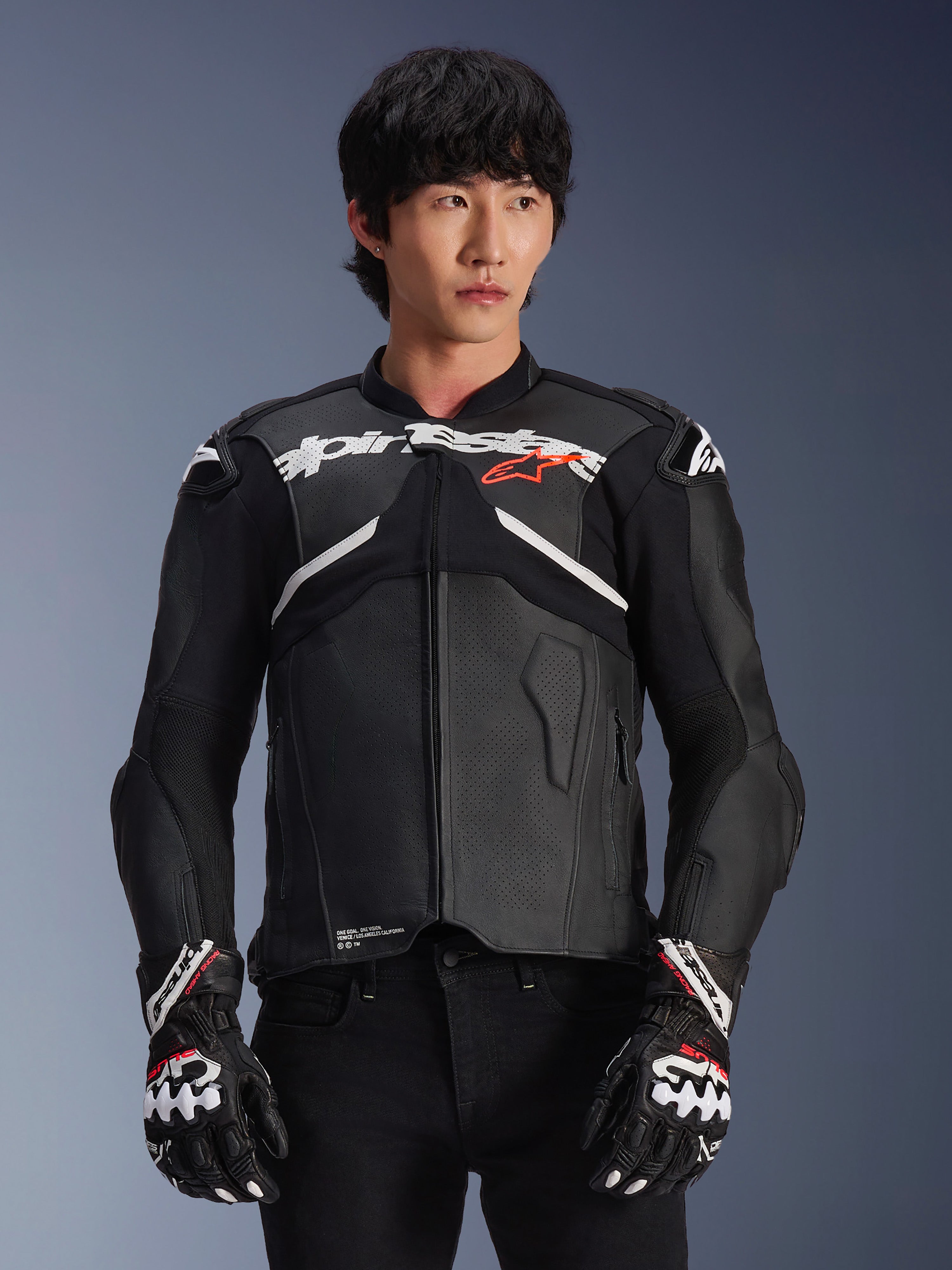 Alpinestars Atem V5 läderjacka, motorcykelracingjacka, svart med vita och röda detaljer, premium läderkonstruktion med inbyggda skydd, bärs med matchande racinghandskar