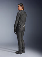 Alpinestars Stella Dusk läderjacka, motorcykeljacka för dam, svart och vit, vy bakifrån med vit Alpinestars-logotyp på ländryggen och axlarna, bärs med svarta mc-byxor och stövlar, sportfokuserad ergonomisk passform för vägkörning