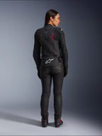 Alpinestars Stella Dusk läderjacka, vy bakifrån, svart läder med Diva Pink och vita detaljer, vit Alpinestars-logotyp på nedre delen av ryggen och rosa ventilationsdetaljer, bärs med svarta mc-byxor och stövlar, premium sportmotorcykelutrustning för damer