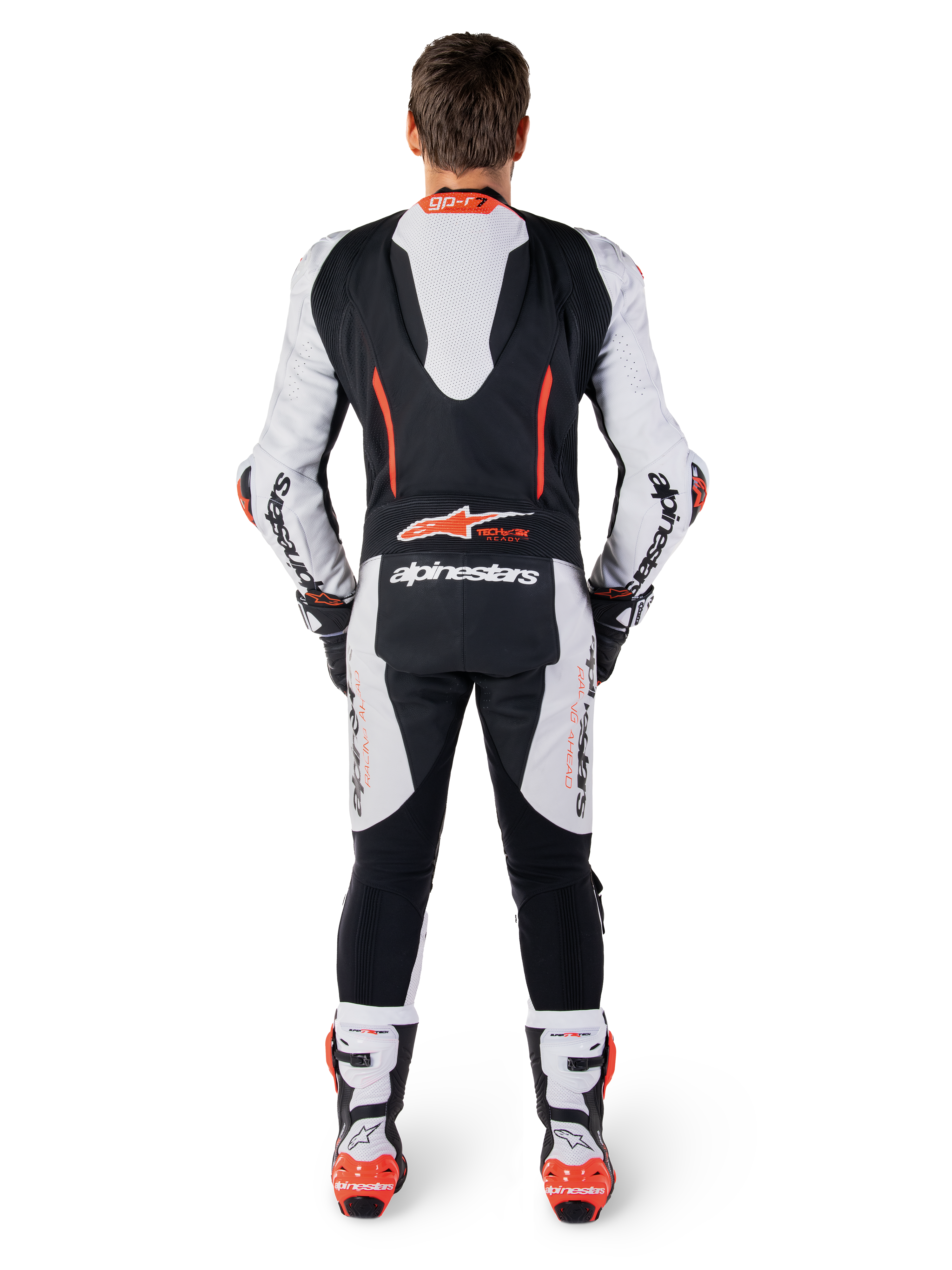 Alpinestars GP-R7 skinnställ, racingoverall i vitt och svart nötläder, vy bakifrån med aerodynamisk puckel och röd fluo-grafik.
