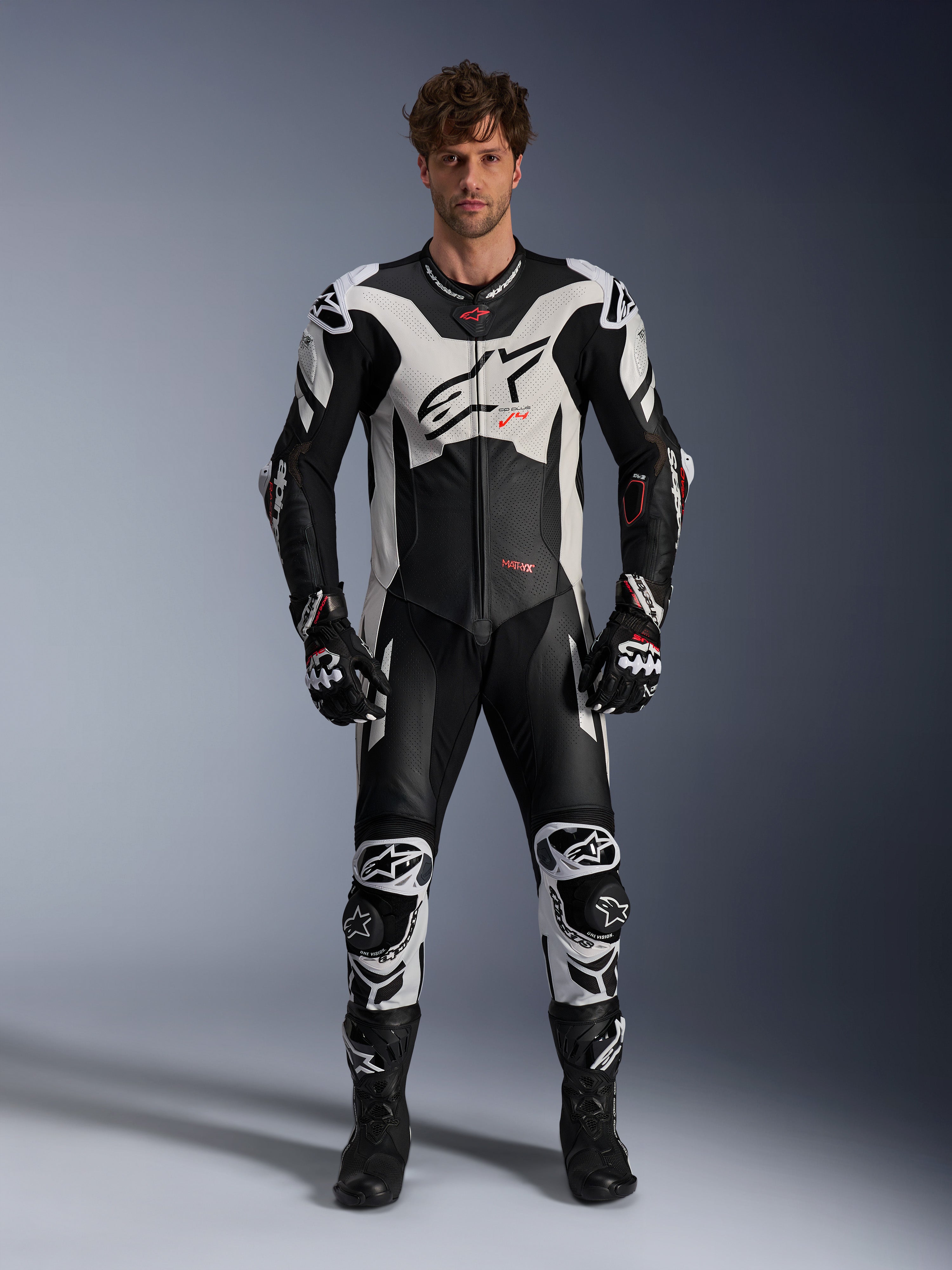 Alpinestars GP Plus V4 Sprint endelat skinnställ, racingoverall för herr, svart och vitt med röd fluo, bärs av en modell.