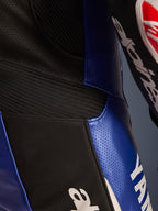 Närbild på Alpinestars Yamaha GP-R7 helställ i läder, metallicblå och svart, med perforerade läderpaneler för ventilation, svarta dragspelspaneler för flexibilitet och tydlig vit Yamaha-logotyp, konstruktion i högkvalitativt nötläder.