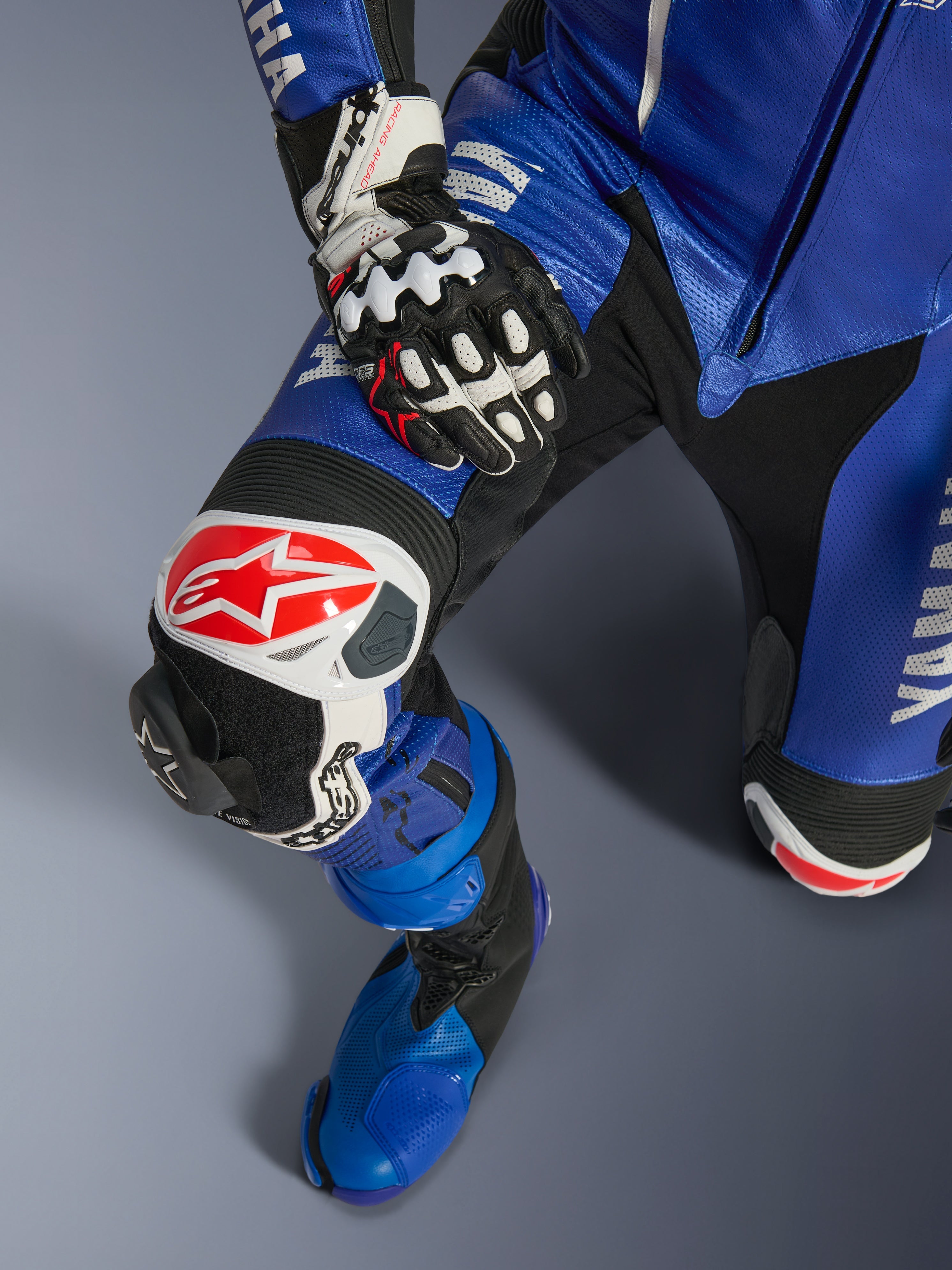 Alpinestars Yamaha GP-R7 endels läderställ, motorcykelställ, metallicblått och svart, med vit och röd Alpinestars-logotyp på knäskyddet, utbytbar GP-knäpuck och matchande blå racingstövel, professionell utrustning redo för banan