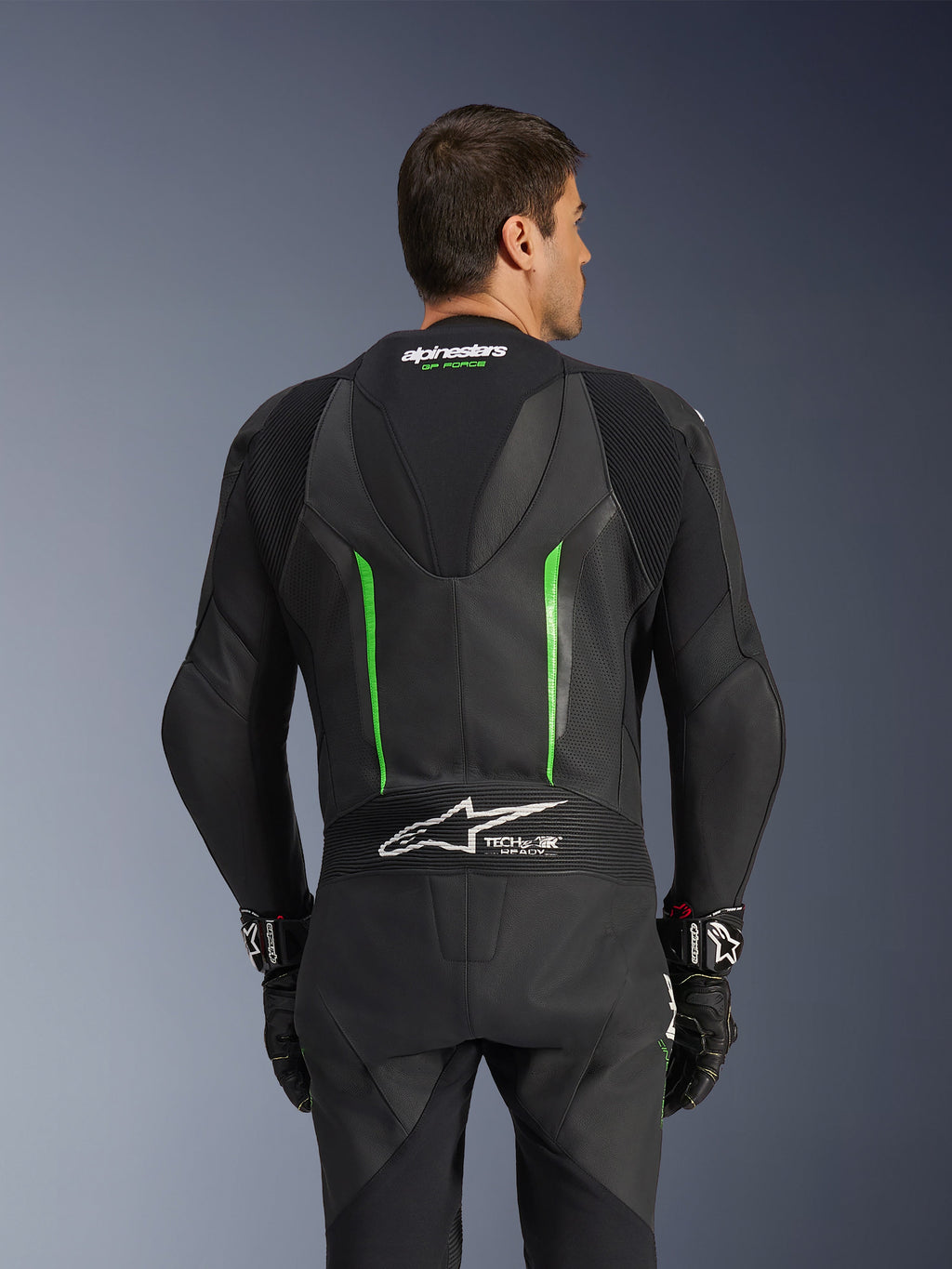 Alpinestars GP Force V2 skinnställ - 1-delat, svart och grön, vy bakifrån med aerodynamisk speedpuckel, Tech-Air Ready-branding, perforerade läderzoner och dragspelsstretchpaneler för motorcykelracing