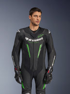 Alpinestars GP Force V2 Skinnställ - 1 del, svart och grönt racingskinnställ för motorcykel, bärs av modell, med perforerade läderpaneler, tydlig vit Alpinestars-logotyp på bröstet och ärmarna, samt integrerat axelskydd för banprestanda