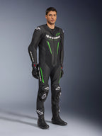 Alpinestars GP Force V2 skinnställ i ett stycke, svart och grönt, komplett racingutrustning buren med svarta handskar och stövlar, med perforerade läderpaneler, vit Alpinestars-logotyp och integrerade knäpuckar, professionellt tävlingsställ för bana