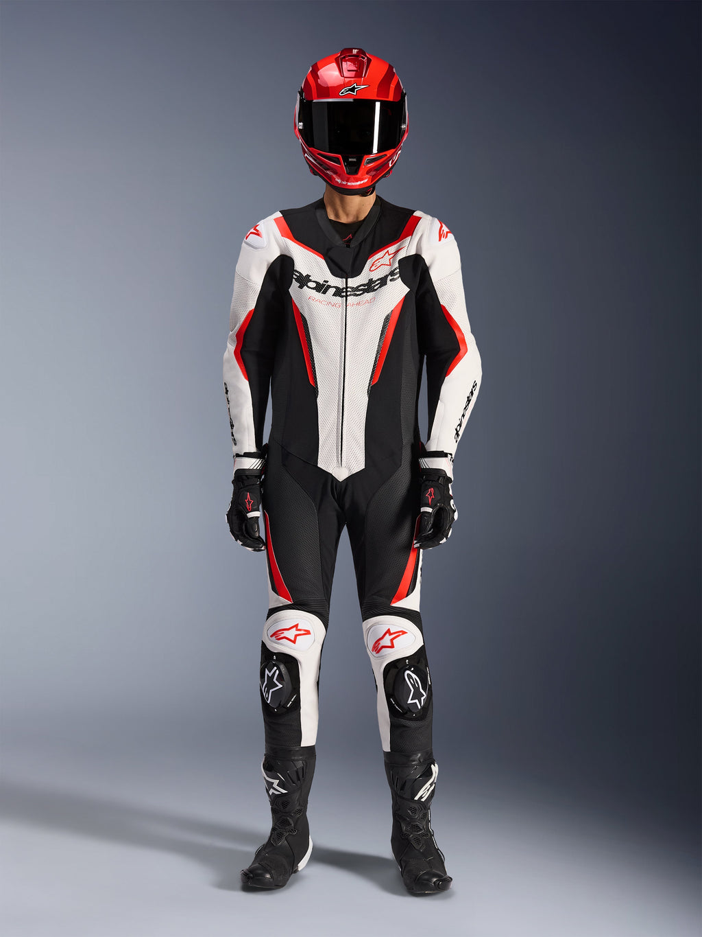 Alpinestars GP Force V2 läderställ - 1 del, vit, svart och röd fluo, komplett racingutrustning inklusive röd hjälm, svarta handskar och stövlar, med aerodynamisk design och Alpinestars-logotyper på bröst och knän